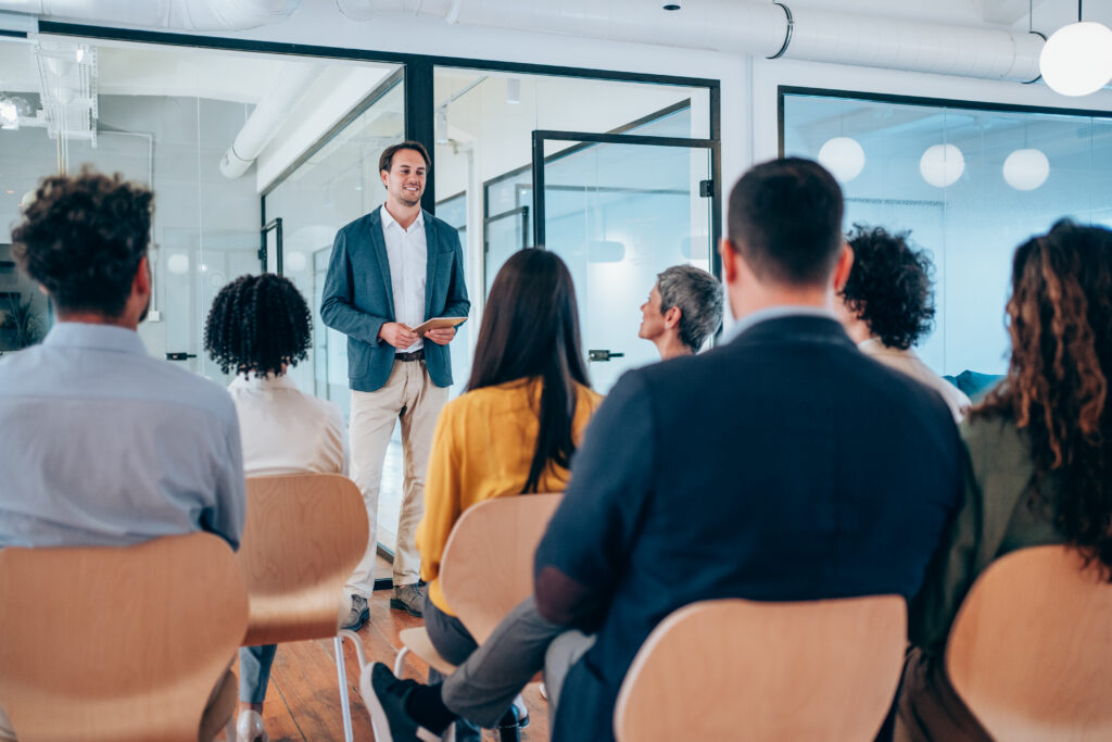 businessman talking to a group of people in a conference hall.